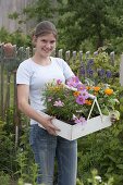 Young woman planting summer flower bed 1/4