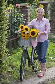 Frau mit Fahrrad und Sonnenblumen