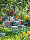 Table with gladiolus-dahlia bouquet under apple tree