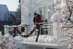 Decorating a balcony with garland for Christmas (2/3)