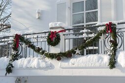 Decorating a balcony with garland for Christmas 2/3