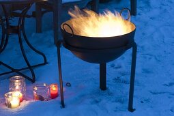 Winterliche Terrasse mit Feuerkorb und Windlichtern