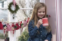 Girl with advent calendar at window