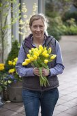 Frau mit gelbem Tulpenstrauß