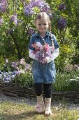 Girl with bouquet of Aquilegia (columbine) and Syringa (lilac)