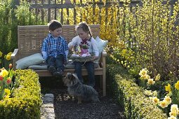 Kinder mit Osternest im Bauerngarten