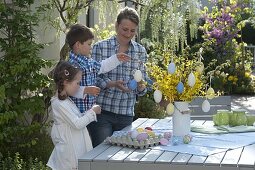 Woman with children decorating Easter bouquet