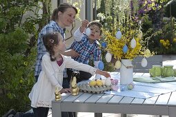 Woman with children decorating Easter bouquet