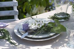 Lilac table decoration in the garden in front of lilac bushes