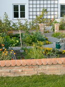 Small cottage garden with wall and greenhouse