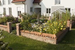 Small cottage garden with wall, fountain in the middle, paved paths