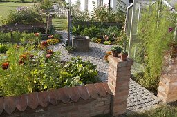 Small cottage garden with wall, well in the middle, paved paths