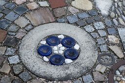 Interestingly paved small terrace between flower beds