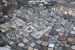 Interessant gepflasterte kleine Terrasse zwischen Beeten