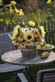 Strauß aus Helianthus (Sonnenblumen) und Dahlia (Dahlien) in Holzkübel