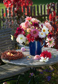 Strauß aus gemischten Dahlia (Dahlien) in blauem Krug und Kranz