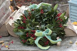 Autumn wreath made of holly with red berries and a felt bow