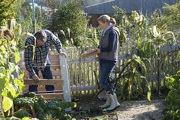 Man and Woman building compost containers together