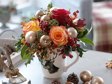 Hirsch-Tasse als Vase mit Rosa (Rosen, Hagebutten), Hedera (Efeu) und Ilex