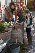 Mother and daughter planting spring box in autumn