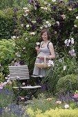 Pregnant woman enjoying the scent in the rose garden and cutting flowers