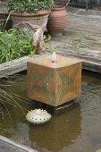 Hand-potted water feature in architectural pond