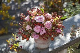 Autumn bouquet of roses and various rosehips