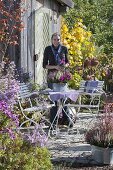 Kleine Herbstterrasse neben Staudenbeet am Gerätehaus