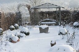 Snow-covered rose beds, Buxus (boxwood balls), hedge, pavilion