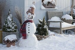 Schneemann mit Tontopf als Hut, Schal, Kohlstrunk als Pfeife, Karotte als Nase