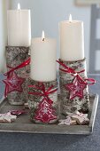 Birkenstämme als Kerzenhalter für weissen Kerzen, weihnachtlich dekoriert