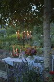 Gedeckter Tisch im Blumengarten unter Walnussbaum