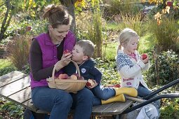 Frau mit Kindern bei der Apfelernte