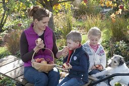 Woman with children harvesting apples