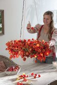 Physalis-Kranz mit Lichterkette als hängende Tischdeko