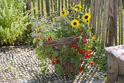 Woman planting summer flowers in homemade wicker basket