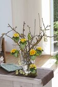 Easter bouquet of twigs, green colored duck eggs planted with primula