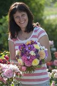 Frau mit Gartenstrauss aus Rosa (Rosen), Hydrangea (Hortensien), Cosmos