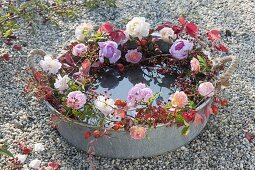 Wreath made of roses around zinc tray with water