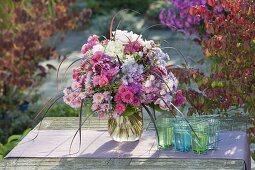 Woman binding autumn bouquet with perennials and grasses