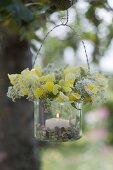 Glas als Windlicht mit Kränzchen aus Blüten von Antirrhinum