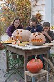 Family carving pumpkins for Halloween