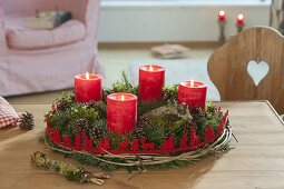 Red-green Advent wreath of mixed conifers and Buxus