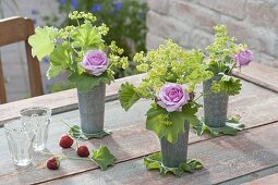 Hohe Zink-Becher als Vasen mit Alchemilla mollis (Frauenmantel) und Rosa