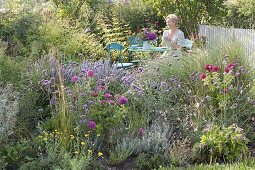 Blau - violettes Beet und Sitzplatz im Naturgarten