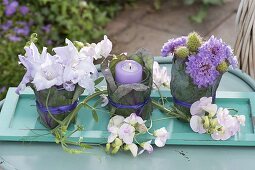 Small table decoration with bouquets and lantern on turquoise coaster