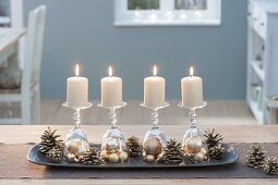 Ungewoehnlicher Adventskranz mit Kerzen auf umgedrehten Gläsern