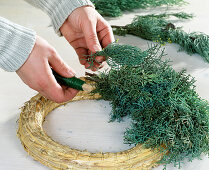 Tying an Advent wreath. Step 2: Lay the twigs on the straw ring.