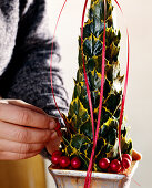 Self-made holly pyramid. Decorate the pyramid e.g. with ribbons.