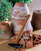 Crushing old clay pots with a hammer